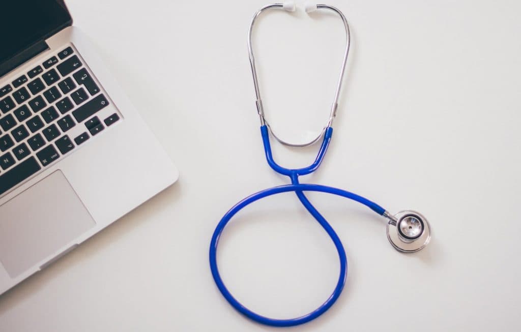 Doctor's stethoscope next to a laptop