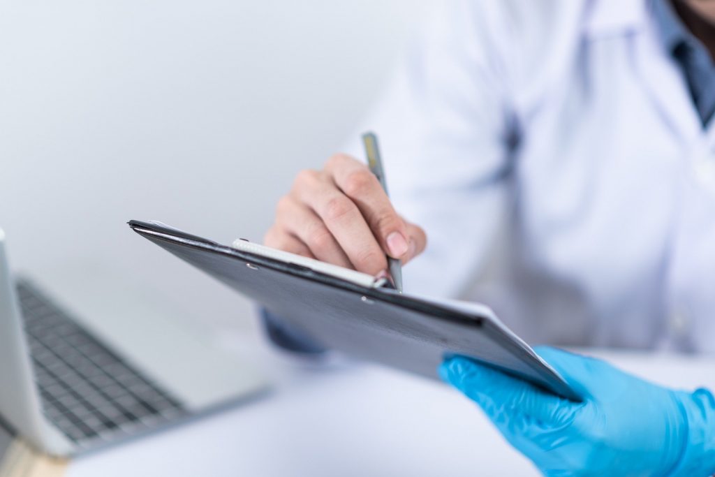 Лекар, преглеждащ данните на пациент преди онлайн консултация
